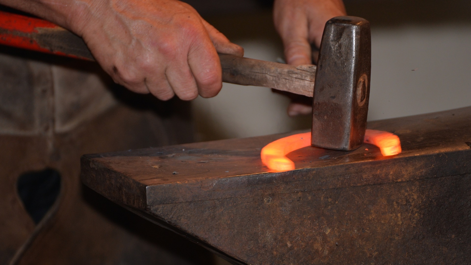 blacksmith hammering a horseshoe